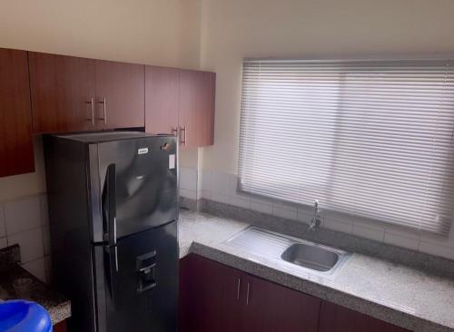 a kitchen with a stainless steel refrigerator and a sink at Suites- Salinas in Salinas