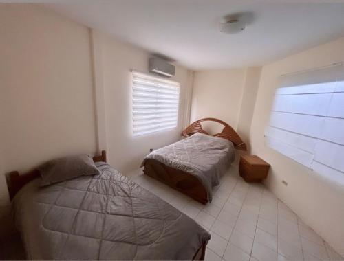 a bedroom with two beds and a window at Suites- Salinas in Salinas