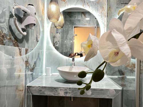 a bathroom with a sink and a mirror at Maison deluxe studios and apartment in Parga