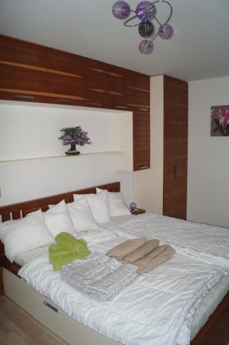 a bedroom with a large white bed with a plant on it at Apartments Klinovec in Loučná pod Klínovcem