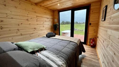 um quarto com uma cama num chalé de madeira em Puerta austral em Puelo