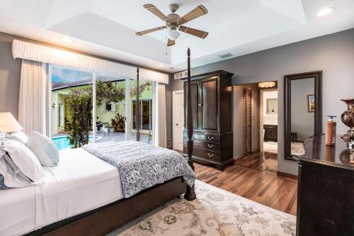 a bedroom with a bed and a ceiling fan at Tropical Oasis with Heated Pool in Boynton Beach