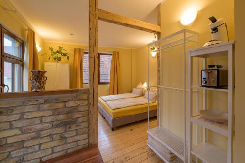 a room with a bedroom with a bed and a microwave at Gästehaus Villa Fliedner - Das Kutscherhaus 