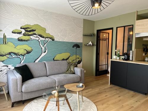 un salon avec un canapé et une peinture d'arbres dans l'établissement Strasbourg, Appartement cosy au bord de l eau, à Strasbourg
