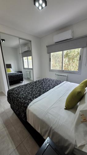 a bedroom with a large bed and a mirror at Pilar Norte. Departamentos in La Lonja