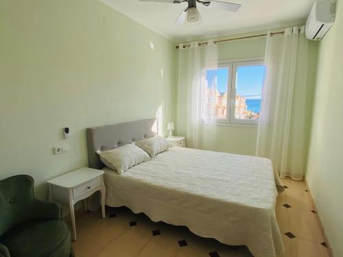 a bedroom with a bed and a window and a chair at Apartment-House La Mata Torrevieja in Torrevieja