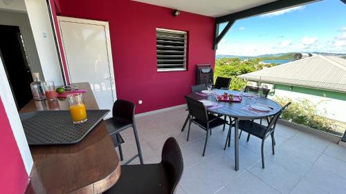 comedor con mesa y sillas en el balcón en La villa Jalna Grenadine deux chambres et piscine privée en Les Trois-Îlets