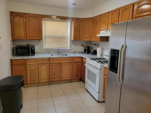 a kitchen with wooden cabinets and a white refrigerator at Traveler's Lodge In Newark City in Newark