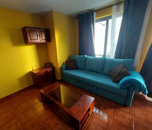 ein Wohnzimmer mit einem blauen Sofa und einem Couchtisch in der Unterkunft Vivienda Vacacional Noni, Los Llanos de Aridane in Los Llanos de Aridane