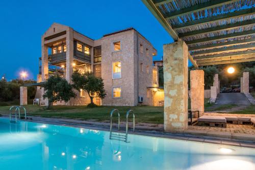 a house with a swimming pool in front of a building at Villa Catani in Kalamaki Chanion