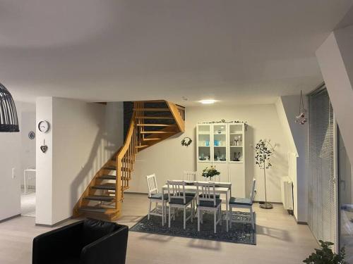 a dining room with a table and a staircase at Citywohnung Würselen in Würselen