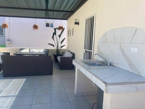 a kitchen with a sink and a living room at Casa del Mar, Sunset Beach, large house for groups in Cabo San Lucas