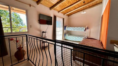 um quarto com uma varanda com uma cama e uma televisão em Valles del Sur - Malargüe em Malargüe