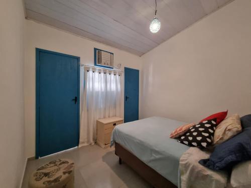 a bedroom with a bed and a blue door at SUÍTES Caminho do Mar in Abraão