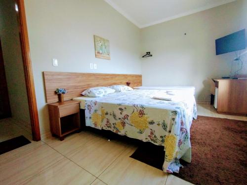 Un pat sau paturi într-o cameră la Pouso Oliveira Suítes
