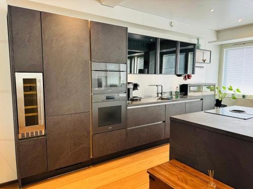 a large kitchen with stainless steel appliances and wooden floors at Turku Central Luxury Modern Cozy Flat 69m2 in Turku
