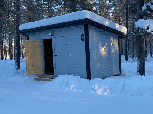 a blue outhouse with a door in the snow at Fjällstuga i avskildhet med elbilsladdare in Idre
