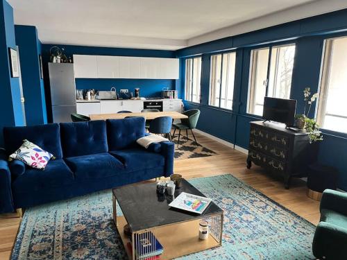 sala de estar con paredes azules y sofá azul en Appartement spacieux 2 chambres avec vue sur le Rhône et parc, en Caluire-et-Cuire