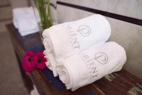 a couple of towels on a table with a flower at Orient Palace in Bielany Wrocławskie