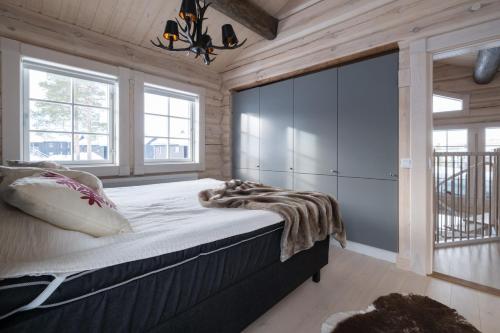 1 dormitorio con 1 cama grande en una habitación con paredes de madera en Exklusiv ski in-ski out stuga, i Hundfjället Sälen en Sälen