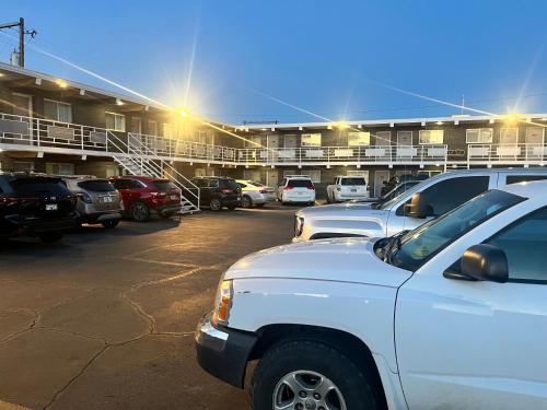 una fila de autos estacionados en un estacionamiento en Tomahawk Motor Lodge, en Riverton