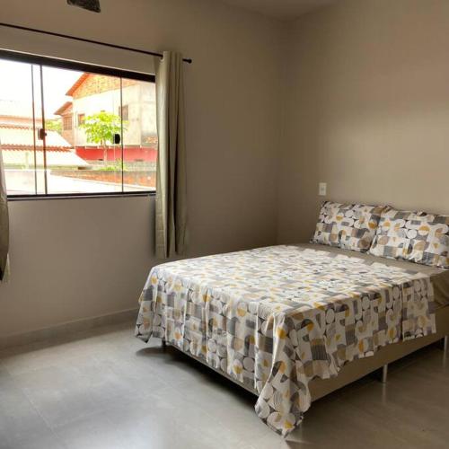 um quarto com uma cama e uma janela grande em Mig 1 em Pirenópolis