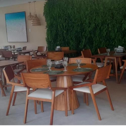 a wooden table and chairs with wine glasses on it at Muro alto - porto de galinhas -Makia beach in Ipojuca