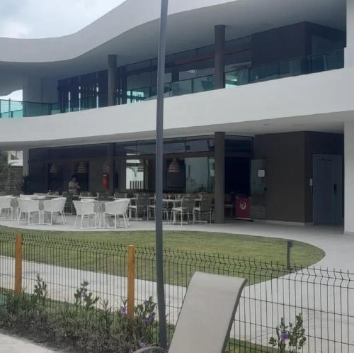 a building with tables and chairs in a courtyard at Muro alto - porto de galinhas -Makia beach in Ipojuca