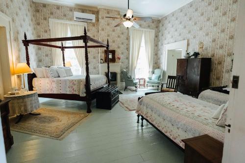 Maple Hill Manor Bed & Breakfast في Springfield: غرفة نوم بسريرين وسرير مظلة