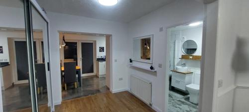 Baño blanco con aseo y espejo en Immaculate 3-Bed House in Hull en Hull