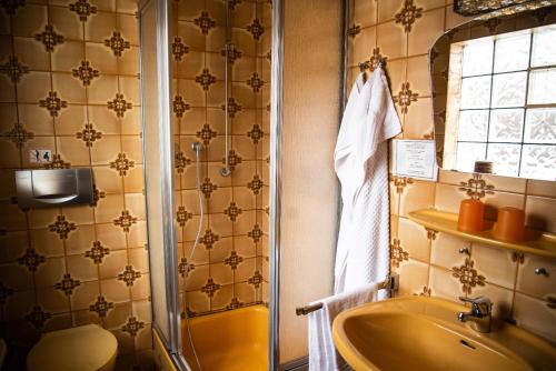 ein Bad mit einem Waschbecken, einer Dusche und einem Waschbecken in der Unterkunft Gasthaus zum Odenwald 