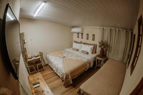 a small bedroom with a bed in a room at Doce Lar Hostel Noronha in Fernando de Noronha