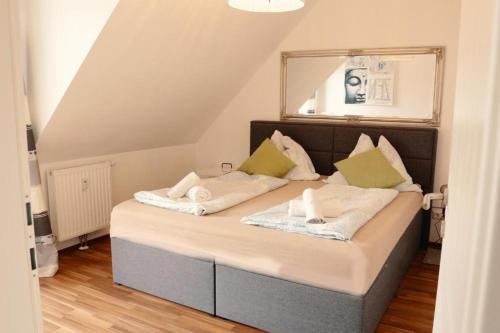 una camera con un letto con due cuscini sopra di Aparthotel Vienna Airport a Himberg