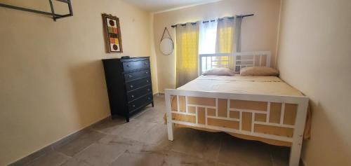 1 dormitorio con 1 cama, vestidor y ventana en Apartahotel Next Nivel, en Punta Cana