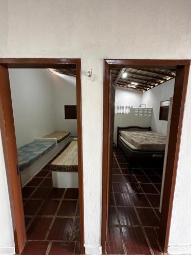 duas camas num quarto com dois espelhos em Casa de praia em camurupim em Nísia Floresta