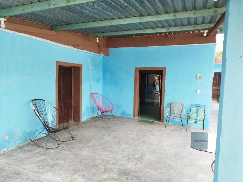 2 sillas sentadas en una habitación con una pared azul en Hostal y Temazcal Guemez en Pisté