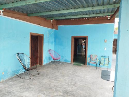 twee stoelen in een kamer met een blauwe muur bij Hostal y Temazcal Guemez in Pisté