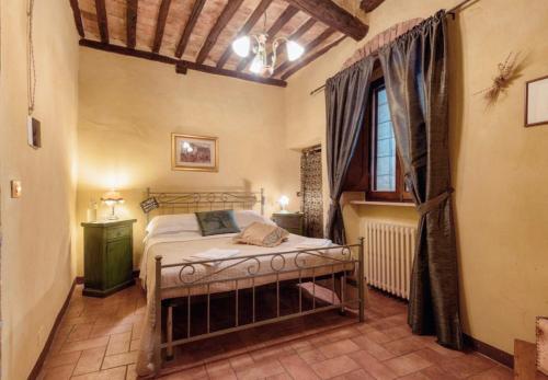 a bedroom with a bed and a window at Guesthouse da Idolina dal 1946 in Montalcino