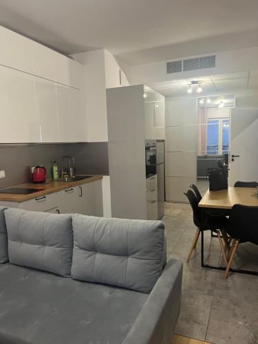 a living room with a couch and a table and a kitchen at Varsovia Tower in Warsaw