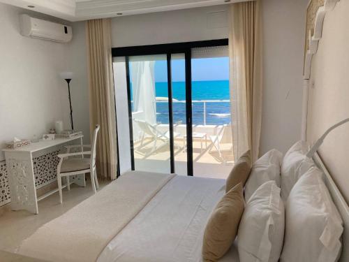 a bedroom with a bed with a view of the ocean at Dar Corniche La Marsa (Adults Only) in La Marsa