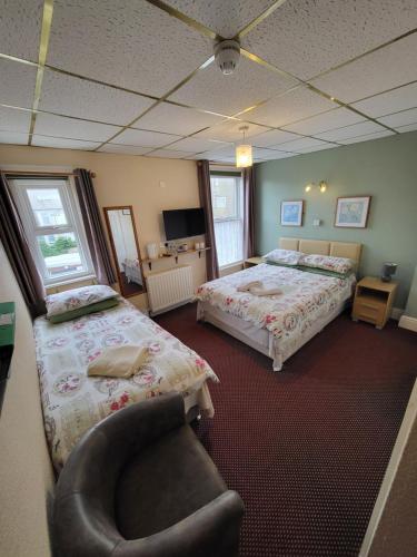 a hotel room with two beds and a chair at The Arabella in Blackpool