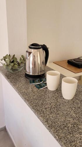 czajnik do herbaty i dwie filiżanki na ladzie w obiekcie Hostería Despeñaderos 
