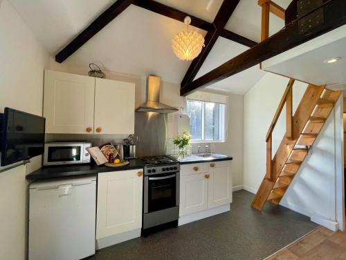 a kitchen with white cabinets and a stove top oven at The Granary in Braunton