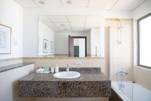 a bathroom with a sink and a mirror at GMA Amwaj 2BR Sea View High Floor in Dubai