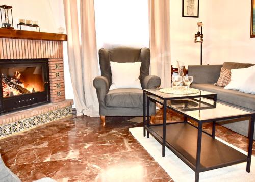 un soggiorno con divano e camino di Casa rural Lomalinda a Granada