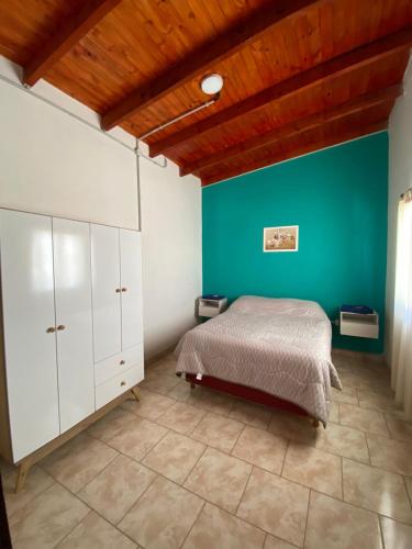 1 dormitorio con cama y pared verde en CATALINA en Neuquén
