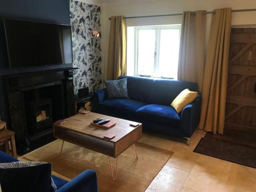 een woonkamer met een blauwe bank en een salontafel bij The Bolt Hole, Cotswold Cottage, Moreton-In-Marsh in Moreton in Marsh