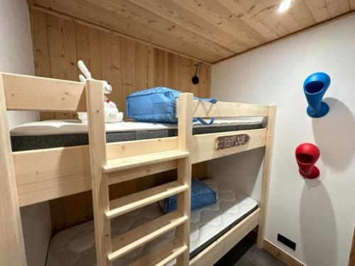 a bunk bed with three bunk beds in a room at TIGNES VAL CLARET A LA CONQUETE DES SOMMETS MOUTIERE B23 in Tignes