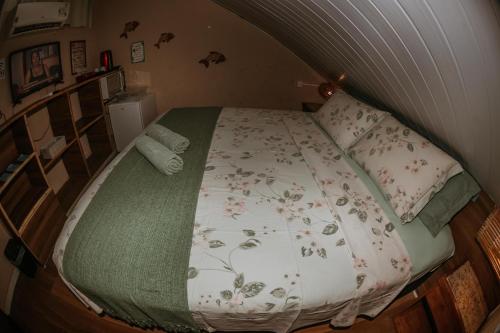 a bedroom with a bed with a floral bedspread at Doce Lar Hostel Noronha in Fernando de Noronha