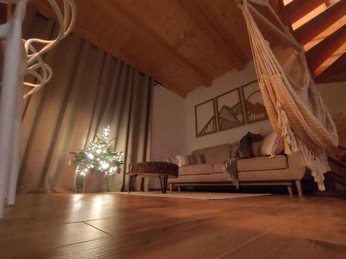 a living room with a hammock and a christmas tree at Beskidzka Kępa Szczyrk - domek z balią i pięknym widokiem na góry in Szczyrk